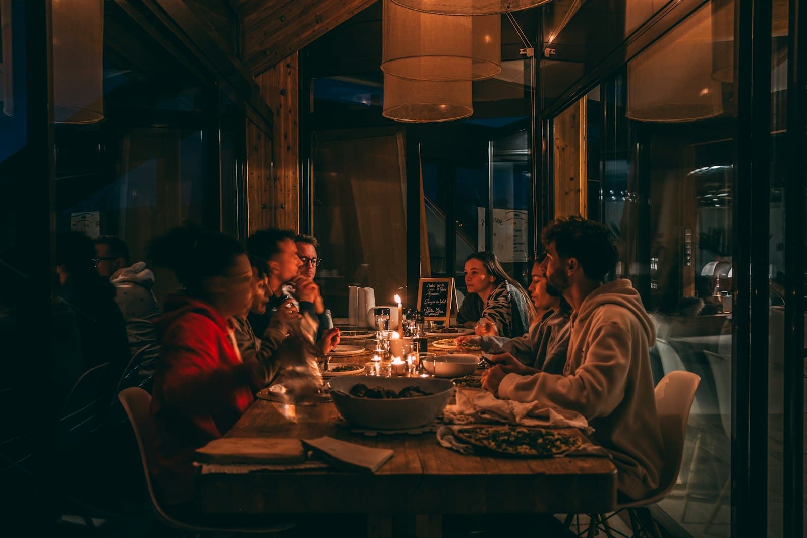 A long table of friends over dinner in a warm dining room