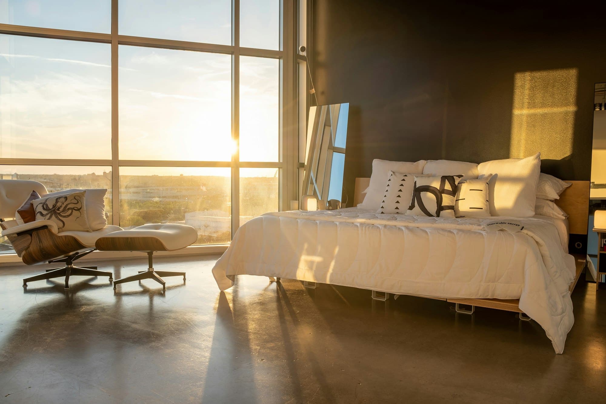 Primary suite with a king bed facing floor-to-ceiling glass