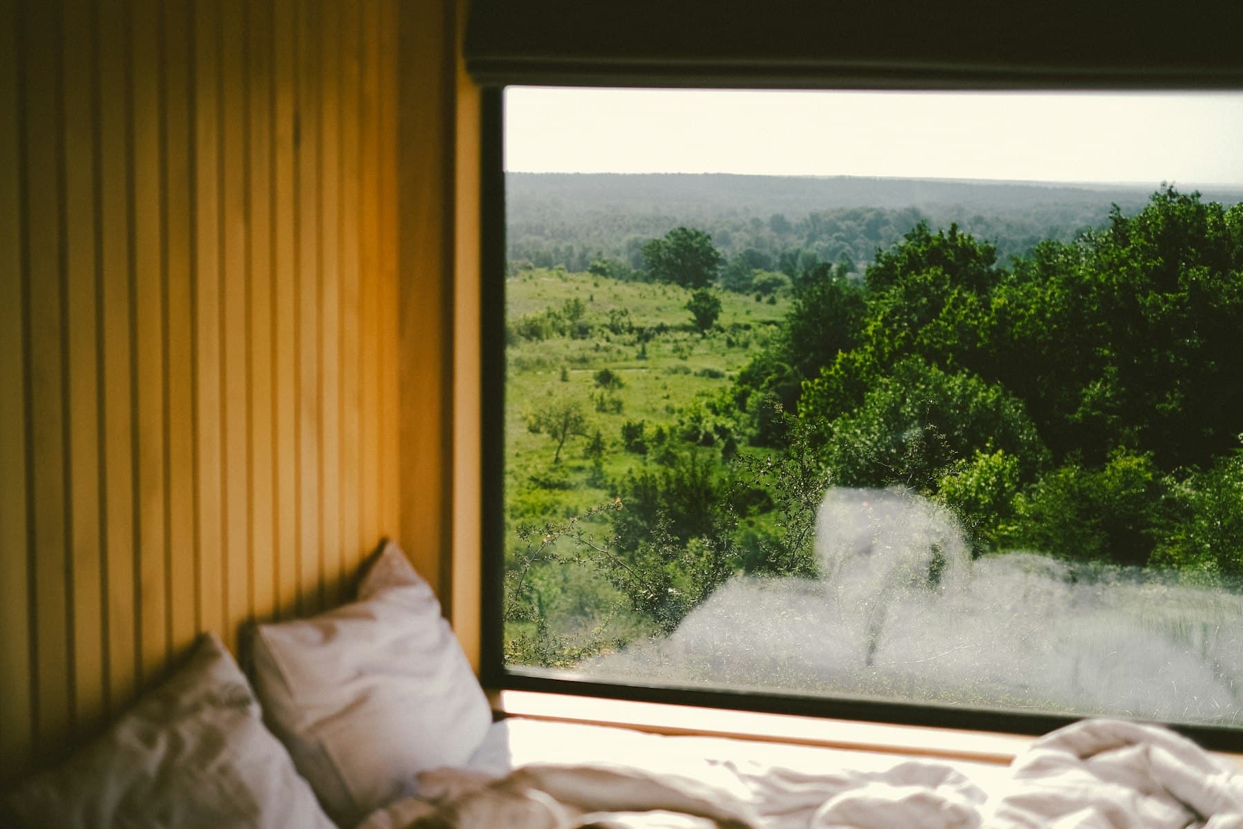 Dune room bed tucked into a panelled window nook