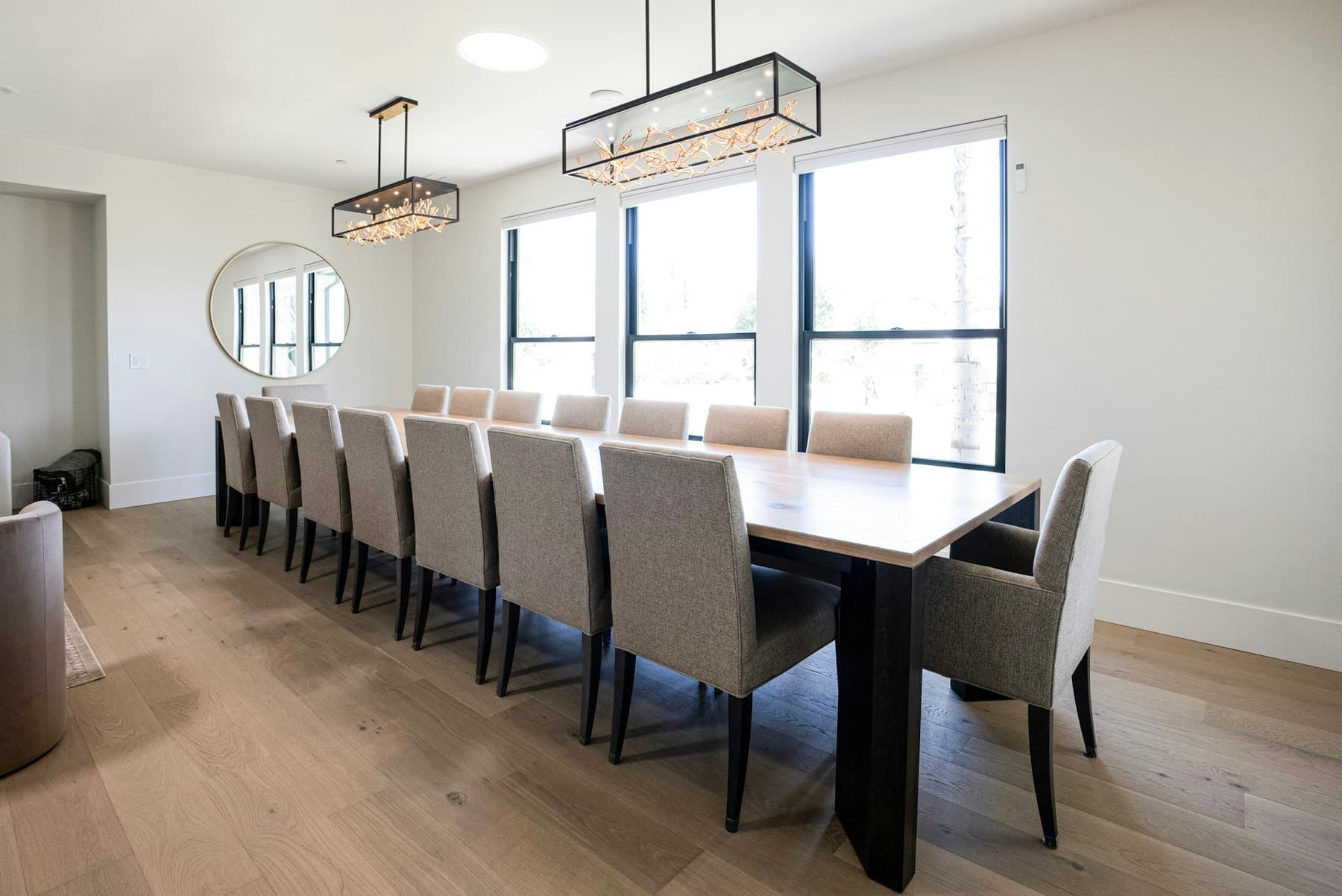 Dining table seating fourteen beneath a linear fixture