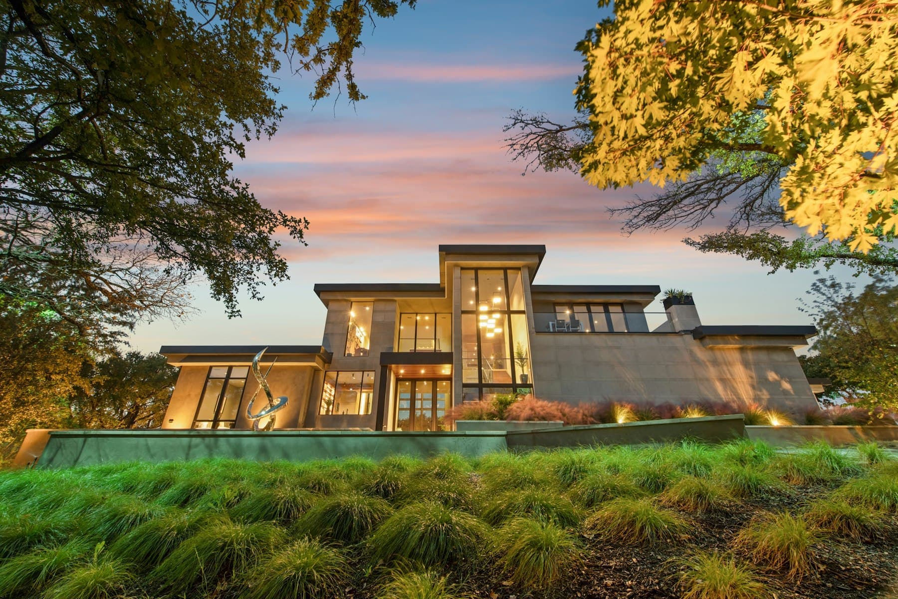 The house at dusk with warm light in every window