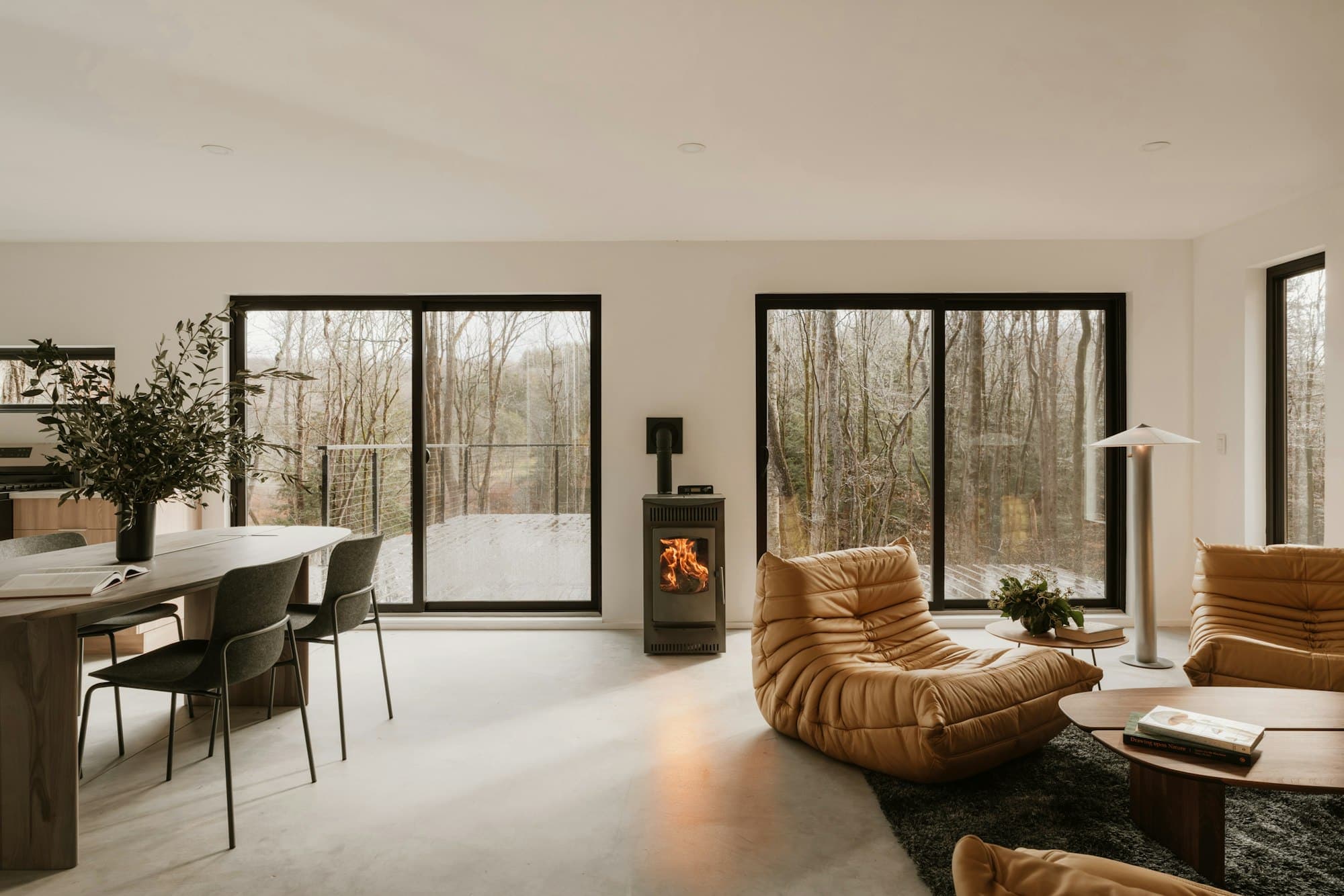 Great room with black-framed windows and a fireplace at the far end