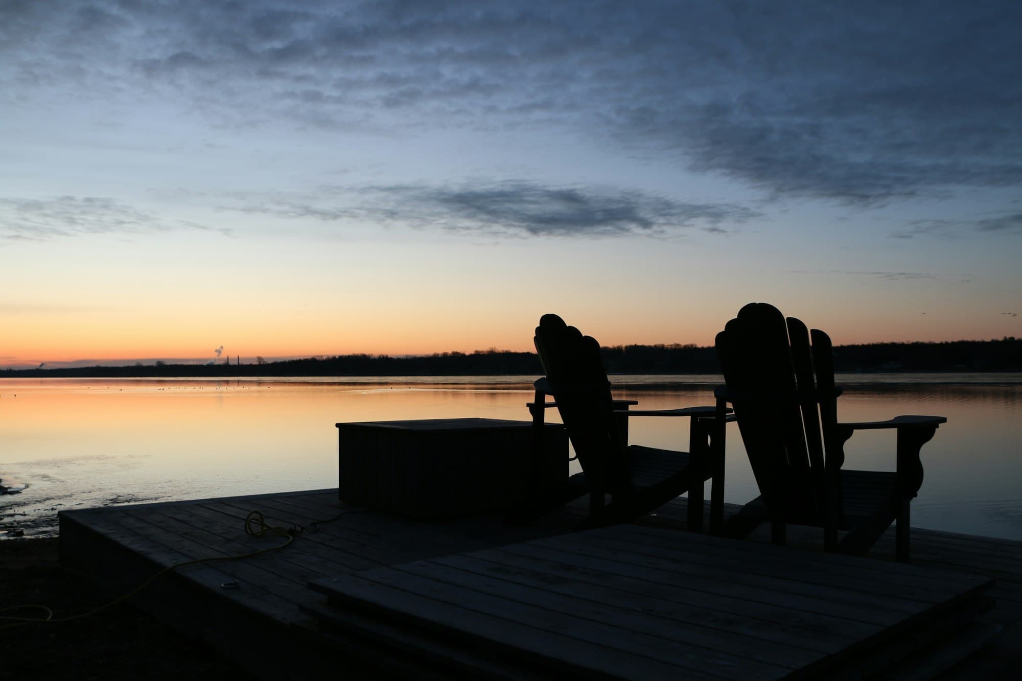 Chairs at the water’s edge as the light goes